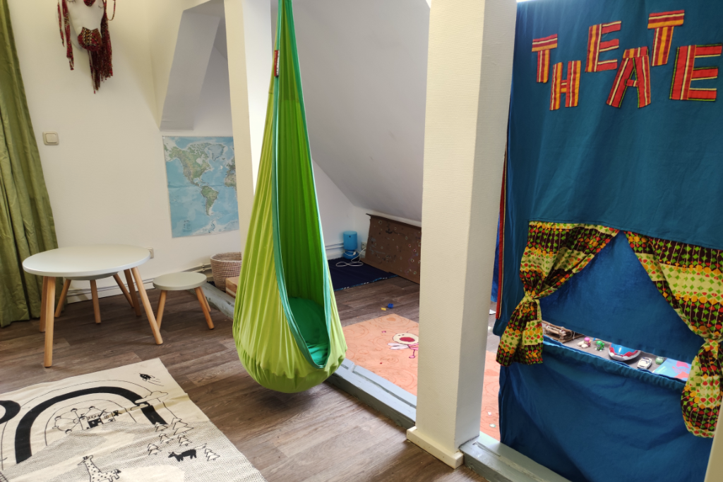 Kinderzimmer mit Teppich auf dem Boden und grünem Sitzsack an der Wand